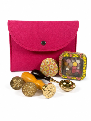 Holly Heide Hot Pink Wax Seal Kit with bright pink felt pouch, three brass wax stamps, colorful wax pearls, floral candle tin and gold pouring spoon.