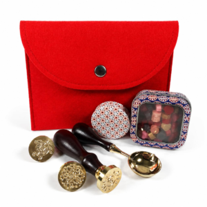 Holly Heide Cherry Red Wax Seal Kit with red felt pouch, three brass stamp designs, wax pearls, candle tin, and gold pouring spoon.