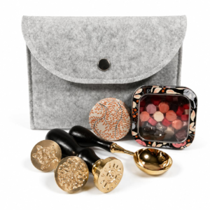 Holly Heide Light Gray Wax Seal Kit with gray felt pouch, three brass stamps, black handles, colorful wax pearls, floral candle tin and gold pouring spoon.