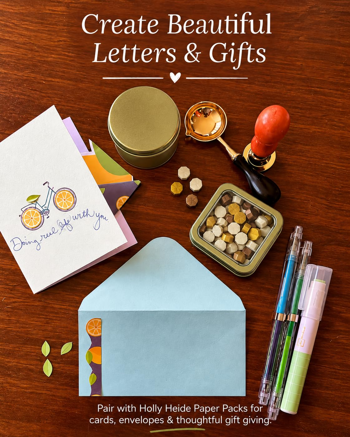 Wax sealing supplies with colorful stationery, greeting card, envelope, wax pearls, brass stamp and pouring spoon for creative letter writing and gifts.